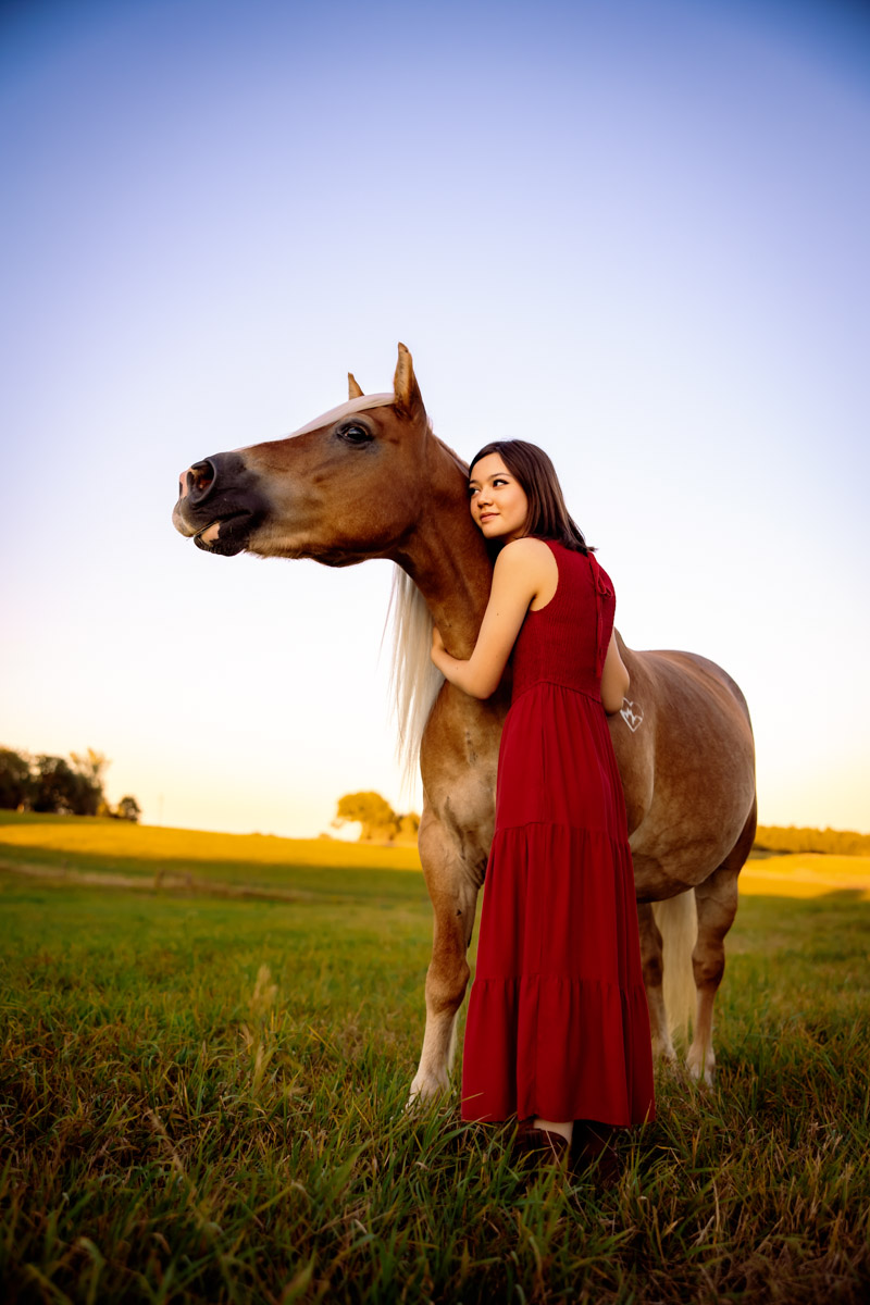 Senior girl in a red dress with her horse