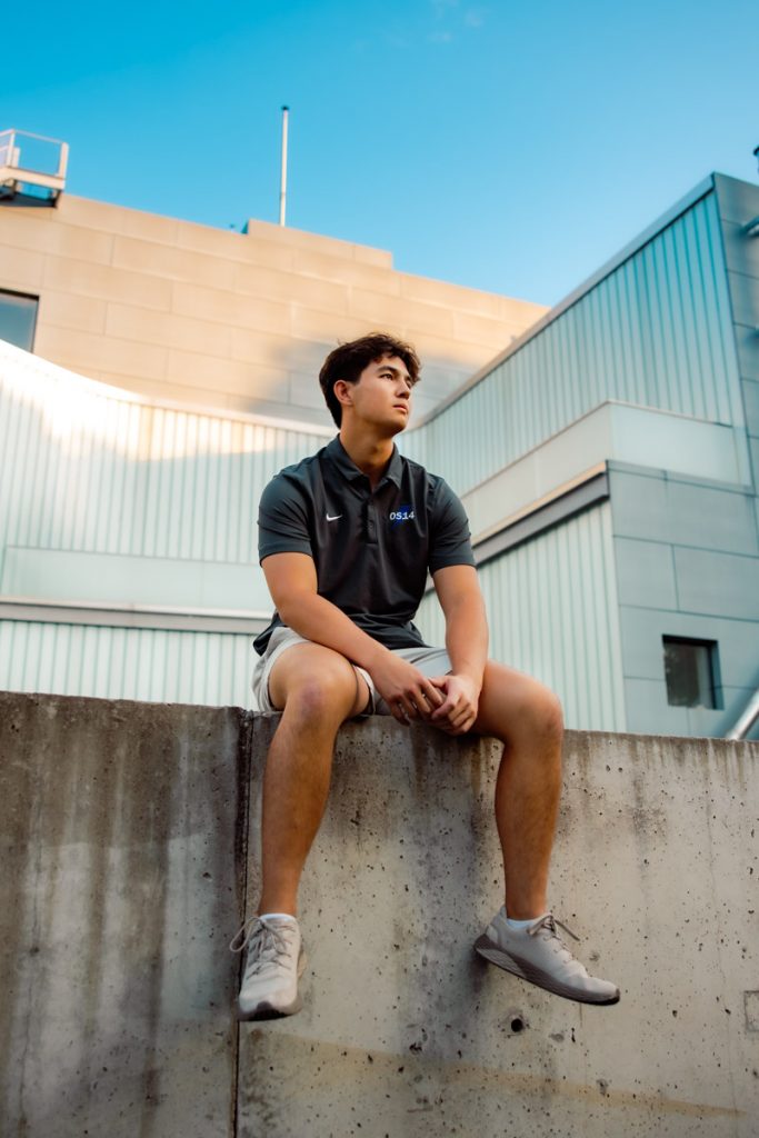 Senior boy sitting on a ledge
