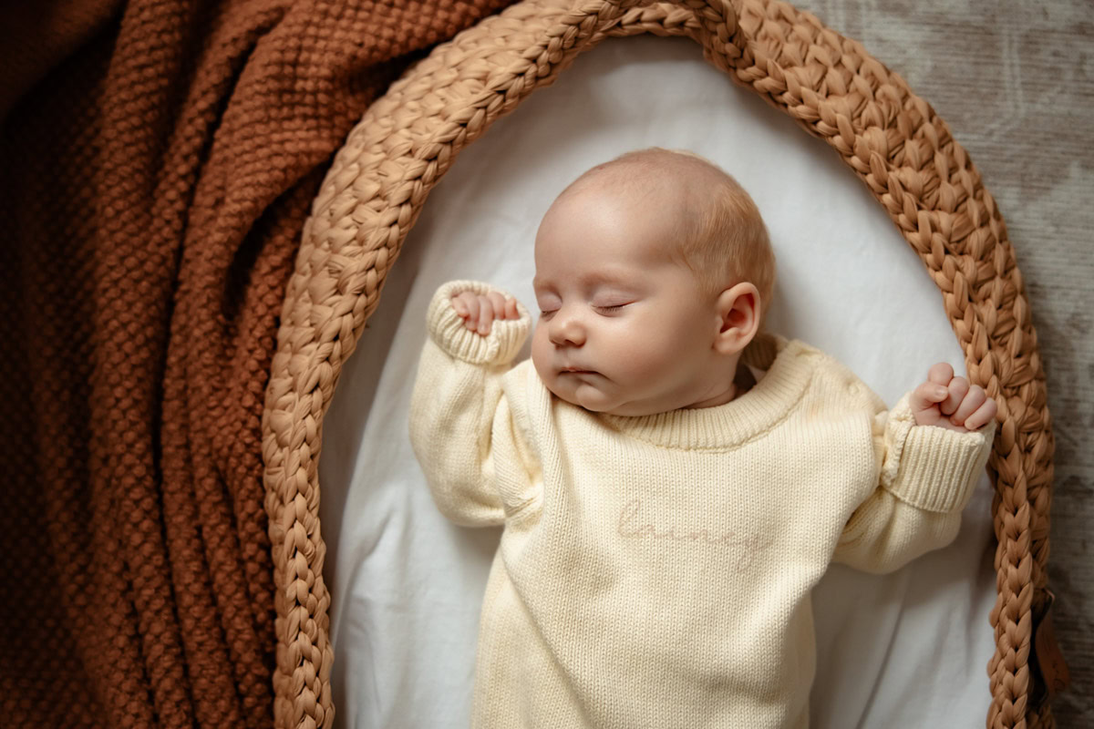 Newborn baby in low moses basket