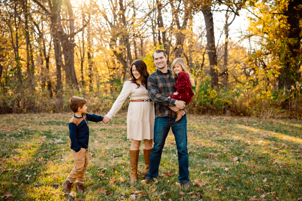Best timing for family pictures: A month-by-month guide Family of four in November in Iowa with nearly bare trees behind