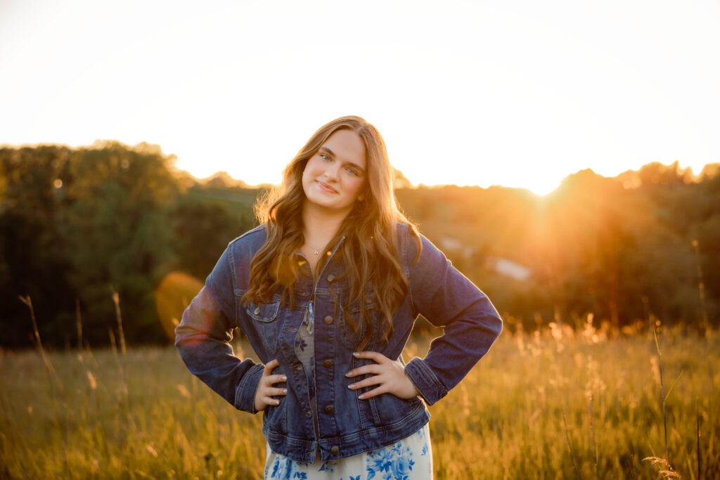 Beginner's guide to senior pictures in Iowa Senior girl in dress at golden hour in a grassy field