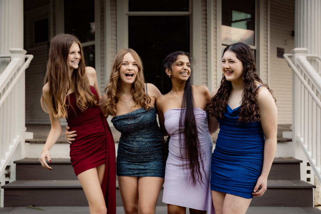 Where to take prom and homecoming pictures in Iowa City, Coralville, and North Liberty Four high school girls in homecoming dresses in North Liberty, Iowa